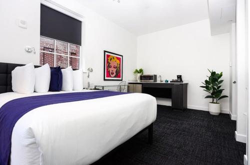 a hotel room with a large bed and a desk at Modern Studio in Historic Boston - Unit #102 in Boston