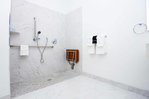 La salle de bains blanche est pourvue d'une douche et d'un téléphone. dans l'établissement Modern Studio in Historic Boston - Unit #102, à Boston
