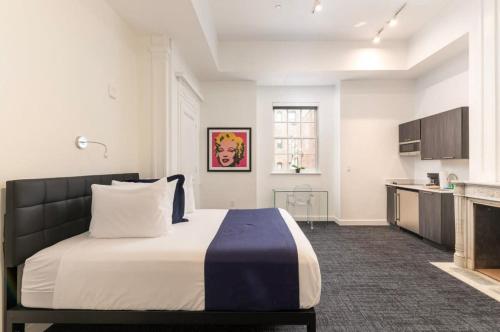 a bedroom with a large bed and a kitchen at Stylish Studio in Historic Boston - Unit #204 in Boston