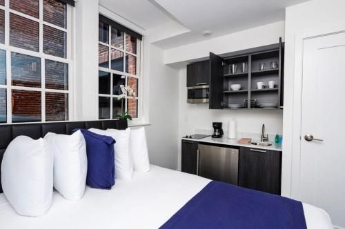 um quarto com uma cama com almofadas brancas e azuis em Modern Studio in Historic Boston - Garden Unit #4 em Boston