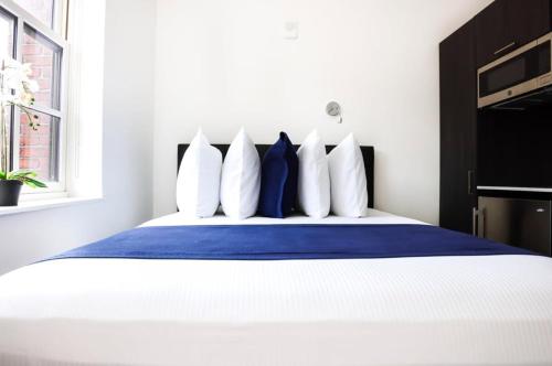 a bedroom with a bed with blue and white pillows at Modern Studio in Historic Boston - Unit #403 in Boston