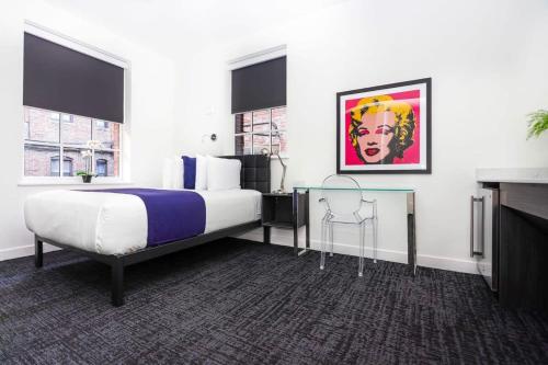 a bedroom with a bed and a painting on the wall at Modern Studio in Historic Boston - Unit #102 in Boston