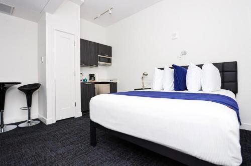 - une chambre dotée d'un grand lit avec des oreillers bleus et blancs dans l'établissement Modern Studio in Historic Boston - Unit #103, à Boston