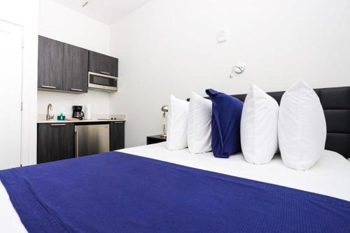 ボストンにあるModern Studio in Historic Boston - Unit #103の青と白の枕が付いたベッドのある寝室