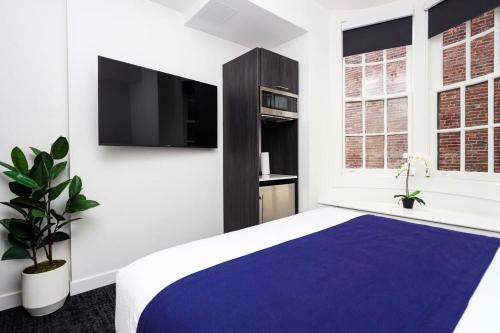 1 dormitorio con 1 cama y TV en la pared en Stylish Stay in Fenway Neighborhood - Unit #304, en Boston