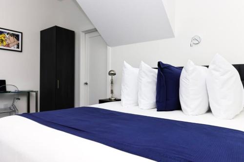 a bedroom with a large bed with blue and white pillows at Stylish Studio in Historic Boston - Unit #405 in Boston