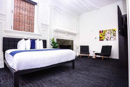 a white bedroom with a bed and a fireplace at Luxurious Studio in the Heart of Boston in Boston