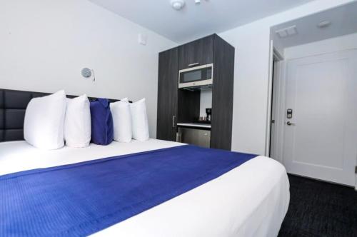 um quarto com uma cama grande com travesseiros azuis e brancos em Modern Studio in Historic Boston - Garden Unit #2 em Boston