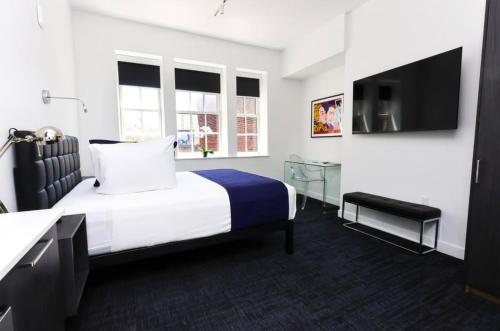 a hotel room with a bed and a flat screen tv at Stylish Studio in Historic Boston - Unit #406 in Boston