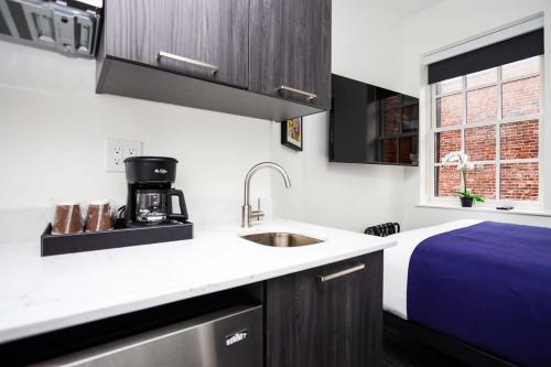 a kitchen with a sink and a bed in a room at Stylish Studio in Historic Boston - Unit #404 in Boston