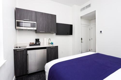 uma pequena cozinha com uma cama e um micro-ondas em Modern Studio in Historic Boston - Unit #101 em Boston