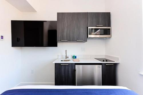 a kitchen with black and white cabinets and a sink at Modern Studio in Historic Boston - Unit #402 in Boston