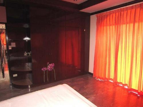 a room with red and yellow curtains and a stage at AA Guesthouse in Pattaya South