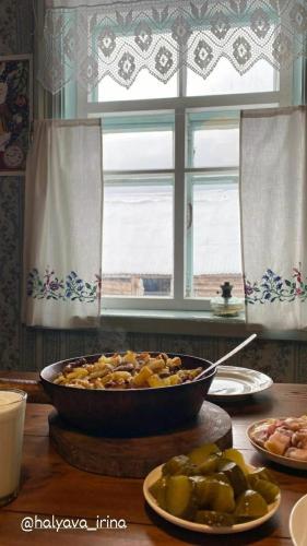een tafel met een kom eten en een raam bij Aisun guest house in Kyzylunkyur