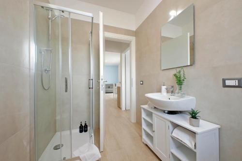 a white bathroom with a sink and a shower at Andrea home- Collegato a Roma e Aeroporto in Fiumicino