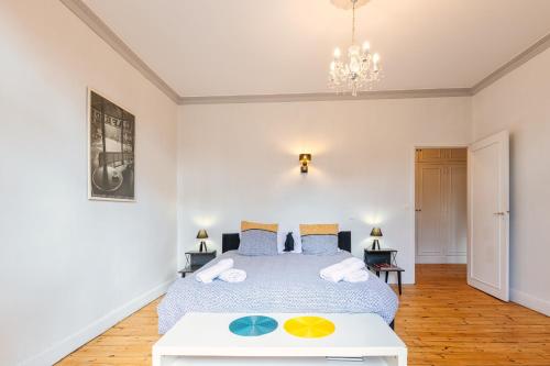 Schlafzimmer mit einem Bett und einem Tisch in der Unterkunft Appartement immeuble le bringer 180m2 in Marvejols