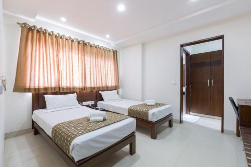 Ένα ή περισσότερα κρεβάτια σε δωμάτιο στο Sanctum Suites BEL Road Bangalore