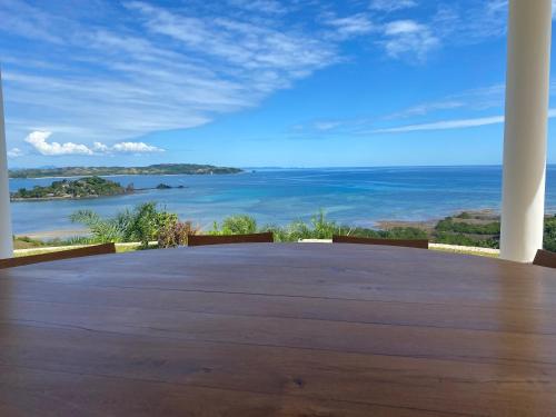 a view of the ocean from the porch of a house at Villa luxueuse avec une vue extraordinaire in Andilana