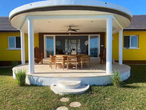 een patio met een tafel en een eetkamer bij Villa luxueuse avec une vue extraordinaire in Andilana