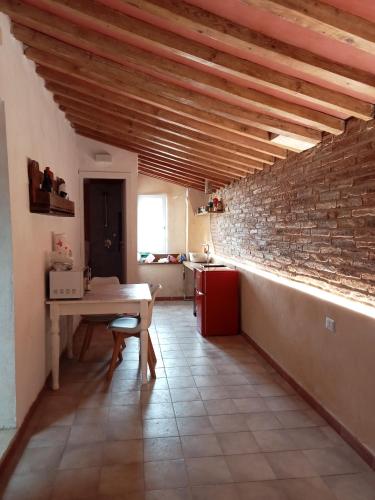 una cucina con tavolo e muro di mattoni di Mansarda Rossi a Livorno