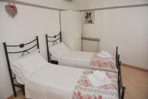 two beds in a room with white sheets at Il Ragno D`Oro in Rho