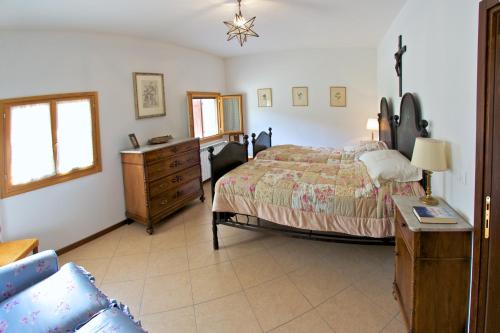 a bedroom with a bed and a dresser and a dresser at Podere Riosto Cantina&Agriturismo in Pianoro