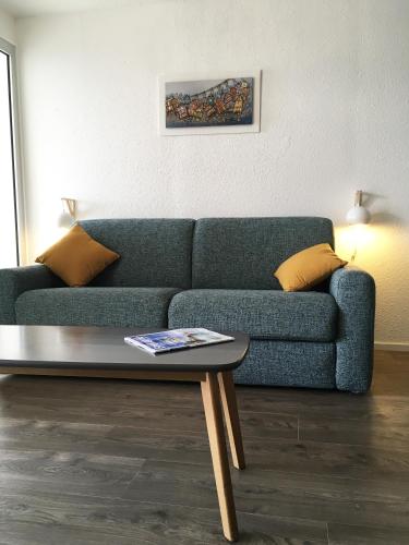 un salon avec un canapé bleu et une table basse dans l'établissement Terrasse sur la Mer, à Audierne