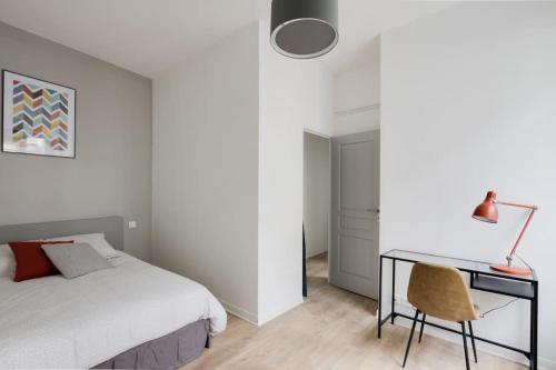 um quarto com uma cama e uma secretária em Aux Clefs des Sacres - Le Chabaud 5 em Reims
