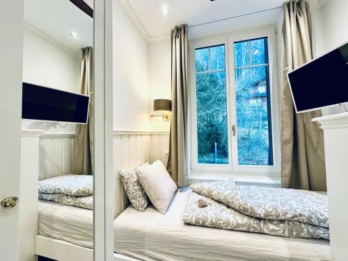 1 Schlafzimmer mit 2 Betten und einem Fenster in der Unterkunft Boutique Hotel Niesenblick - direkt am Thunersee gelegen mit SELF CHECK IN & digitaler Rezeption in Oberhofen am Thunersee