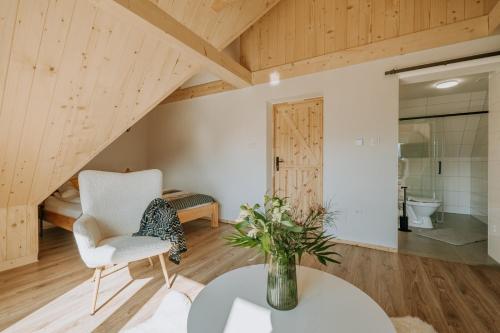 a living room with a white chair and a table at Apartamenty widokowe Zakopane in Zakopane