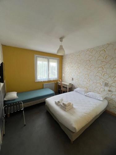 a bedroom with two beds and a window at Hotel Le Cormier 9 in Cholet