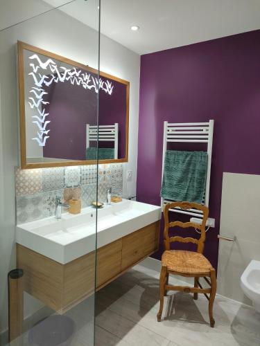 La salle de bains est pourvue d'un lavabo, de toilettes et d'une chaise. dans l'établissement MAISON BELLEVUE LAC ET VERDON, à Saint-Laurent-du-Verdon