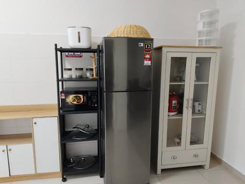 a stainless steel refrigerator next to a cabinet in a kitchen at Safiyya Homestay in Kluang