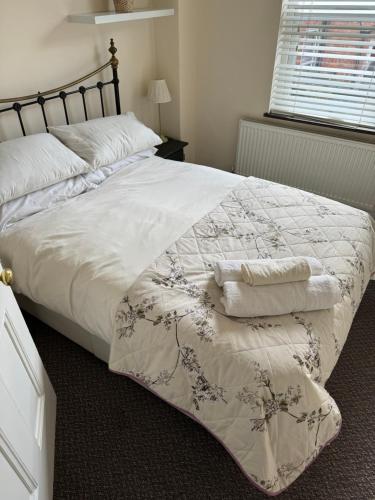 a bedroom with a large bed with a white comforter at Mill Hill Stays in Derby