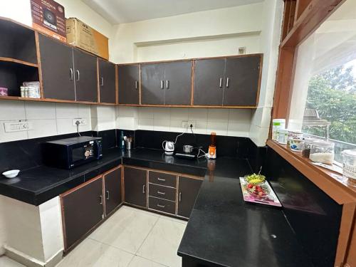 a kitchen with a black counter top and a microwave at Guru Mehar in Ludhiana
