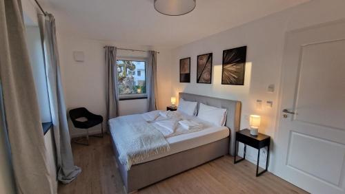 1 dormitorio con 1 cama con 2 lámparas y una ventana en Ferienhaus Sisi - Moderner Neubau im Grünen, nahe See, S-Bahn und mit E-Ladesäule en Pöcking