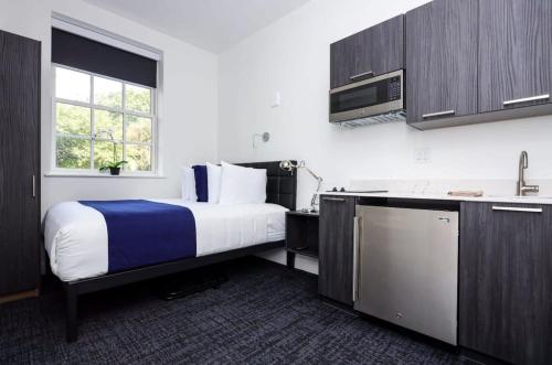 a hotel room with a bed and a kitchen at Stylish Studio the Fenway Neighborhood - Unit #106 in Boston