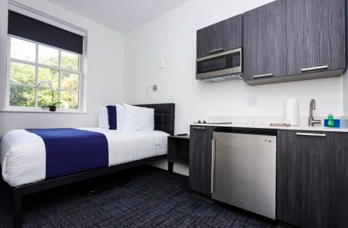 ボストンにあるStylish Studio the Fenway Neighborhood - Unit #106のベッドとキッチンがあるホテルの部屋