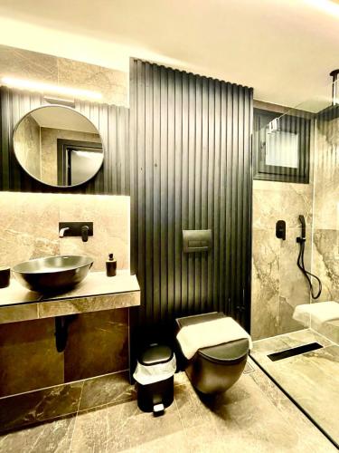 a bathroom with a sink and a toilet and a mirror at Modern Home Loft in Alexandroupoli