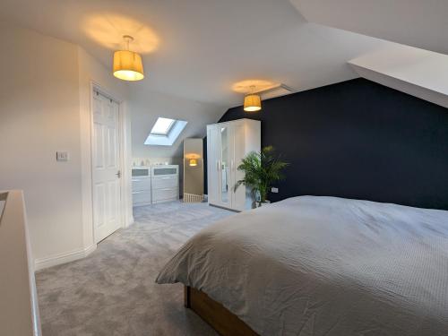 1 dormitorio con 1 cama grande y pared azul en Stunning Super Kingsize Room - Cheltenham Festival, en Cheltenham