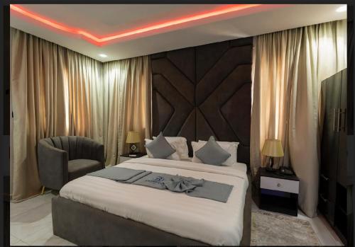 Cette chambre comprend un grand lit et une chaise. dans l'établissement Brimuyo Hotel, à Omole