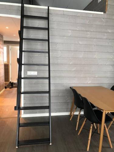 a ladder next to a table and a table and chairs at Lake house by Storsjön in Östersund