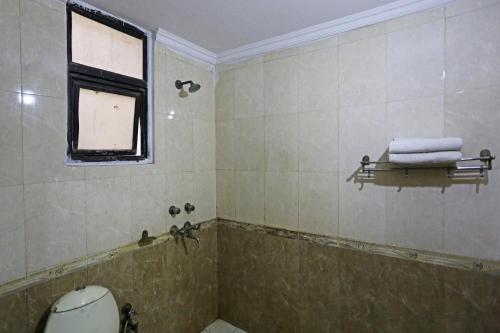 a bathroom with a tub and a window and towels at Hotel Ratandeep at Paharganj in New Delhi