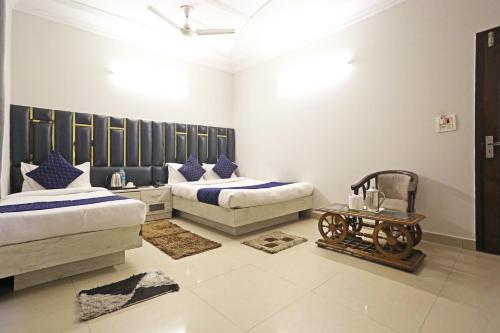 a bedroom with two beds and a table in it at Hotel Ratandeep at Paharganj in New Delhi