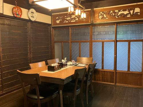 uma sala de jantar com uma mesa de madeira e cadeiras em KIX House Wakeikan 和憩館 em Izumi-Sano