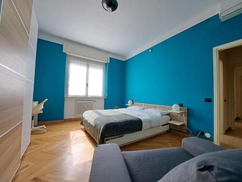 a blue bedroom with a bed and a couch at Echo of the bells in Como