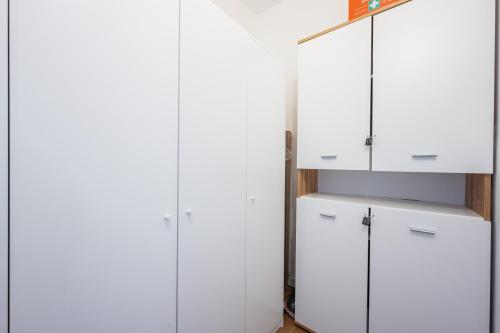 eine Reihe weißer Schränke in einem Zimmer in der Unterkunft Modernes Apartment Wels City Center, TG-Stellplatz in Wels