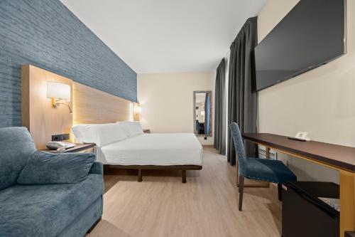 um quarto de hotel com uma cama e um sofá em Hotel Zentral Gijón Rey Pelayo em Gijón