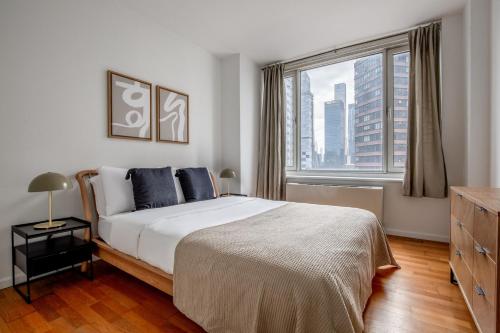 a bedroom with a bed and a large window at Blueground Hells Kitchen gym wd nr museum NYC-1436 in New York