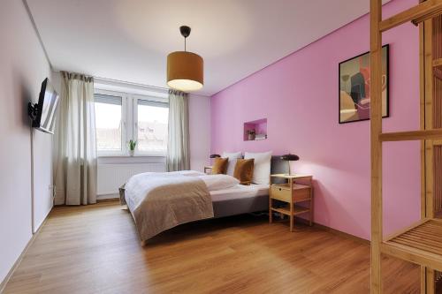 a bedroom with a pink wall and a bed at homie stay Badgasse - Fewos am Main mit Dachterrasse & Fahrradgarage in Ochsenfurt